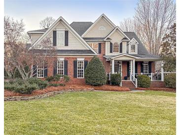 Two-story home with brick and siding exterior, landscaping, and a large yard at 353 Killian Ct, Matthews, NC 28104