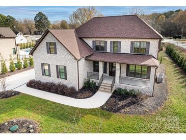 Two-story house with brick facade, brown roof, and landscaped lawn at 719 Greenbriar Dr, Matthews, NC 28104