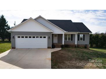 Charming single Gathering home with a two car garage, covered porch, and manicured lawn at 118 Cypress Acres Ln, Statesville, NC 28625