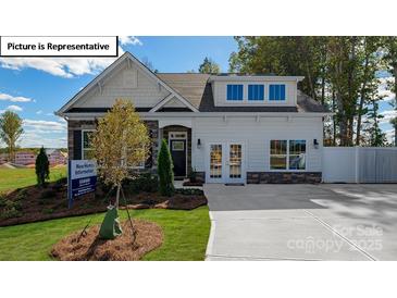 Two-story craftsman style home with stone accents and a landscaped lawn at 1014 Merganser Way, Indian Trail, NC 28079