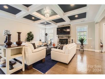 Spacious living room features hardwood floors, a fireplace, and coffered ceiling at 4008 Pinot Way, Indian Land, SC 29707