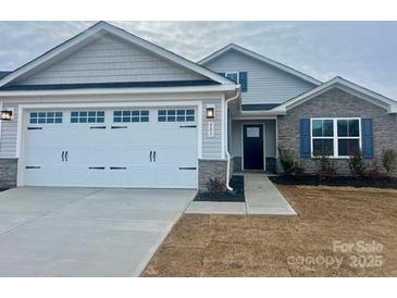 Two-story house with gray siding, stone accents, and a two-car garage at 605 Nesbe St # 2228, Lancaster, SC 29720