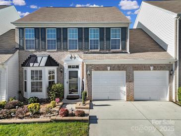 Brick front two-story home with two-car garage and landscaped gardens at 9450 Shumacher Nw Ave, Concord, NC 28027