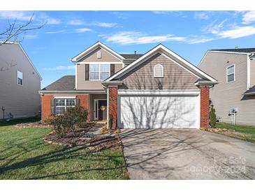 Two-story house with brick and siding, two-car garage, and landscaped lawn at 13917 Sugar Oats Ln, Charlotte, NC 28213