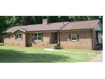 Brick ranch house with brown roof, nicely landscaped lawn at 1426 Reid Harkey Rd, Matthews, NC 28105