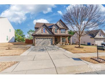 Two-story house with stone accents and a three-car garage at 112 Marquette Dr, Mount Holly, NC 28120