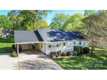 Charming one-story home featuring a covered carport, well-maintained lawn, and a welcoming front porch at 3309 E Broad St, Statesville, NC 28625