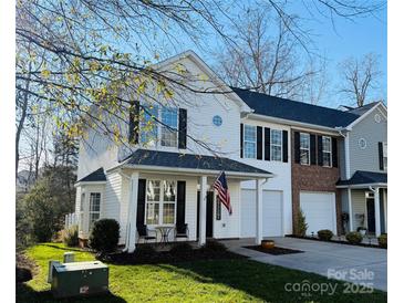 Two-story townhome with white siding, black shutters, and a small front porch at 711 Torrey Pines Ln, Fort Mill, SC 29715