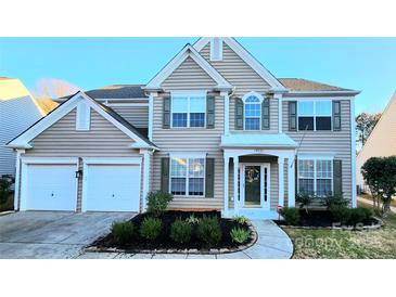 Two-story house with taupe vinyl siding, two-car garage, and landscaping at 14021 Eldon Dr, Charlotte, NC 28277