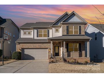 Two-story brick home with gray accents, a two-car garage, and a landscaped yard at 1878 Sapphire Meadow Dr, Fort Mill, SC 29715