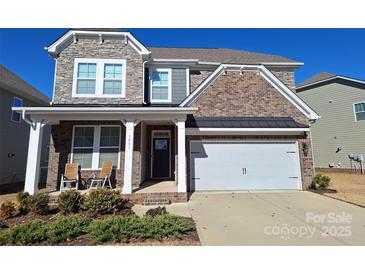 Two-story brick home with a front porch and two-car garage at 3001 Burton Point Ct, Waxhaw, NC 28173