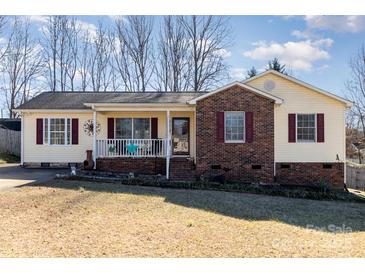 Brick ranch house with a yellow exterior, covered porch, and landscaped yard at 410 E Louisiana Ave # 2, Bessemer City, NC 28016