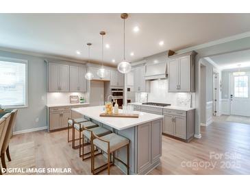 Modern kitchen with gray cabinets, white countertops, and a large island at 9931 Cask Way, Huntersville, NC 28078