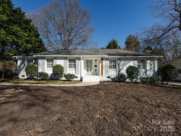 Charming exterior featuring a landscaped yard, white-painted brick, grey shutters, and a welcoming front entrance at 7037 Wrentree Dr, Charlotte, NC 28210