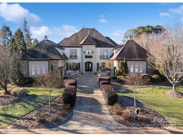 Grand home with manicured landscaping and a welcoming brick walkway to the front entrance at 3042 Kings Manor Dr, Weddington, NC 28104