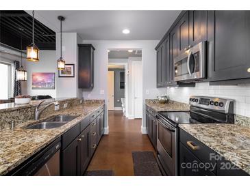 Modern kitchen featuring stainless steel appliances, granite countertops, and dark wood cabinetry at 2338 Yadkin Ave # 505, Charlotte, NC 28205