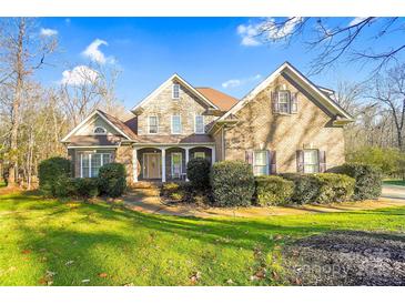 Charming two-story home with a stone and brick facade, mature landscaping, and a welcoming front porch at 3613 Savannah Way, Monroe, NC 28110