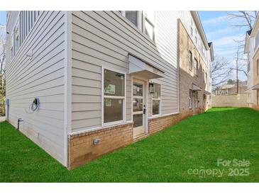 Townhome rear entry with attached garage and grassy yard at 3717 Lou Ann Ave, Charlotte, NC 28208