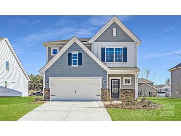 Two-story house with gray siding, white garage door, and landscaping at 4540 Dusty Orchard Rd, Kannapolis, NC 28081