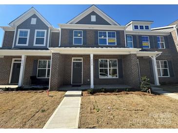 Charming townhome with a brick facade, covered porch, and inviting curb appeal in a well-maintained community at 5552 Stafford Rd # 28, Charlotte, NC 28215