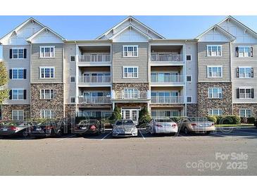 Multi-story condo building with gray and stone facade and ample parking at 6605 Central Pacific Ave, Charlotte, NC 28210