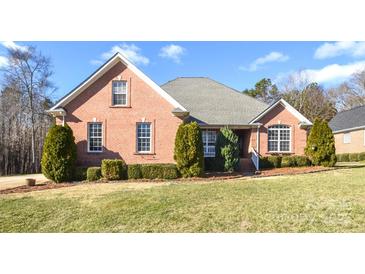 Brick home with landscaped lawn and mature trees at 7757 St Andrews Ln, Stanley, NC 28164