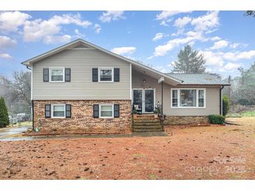 Two-story home featuring vinyl siding, brick accents, and a well-maintained front yard on a cloudy day at 939 Malotte Ln, Gastonia, NC 28054