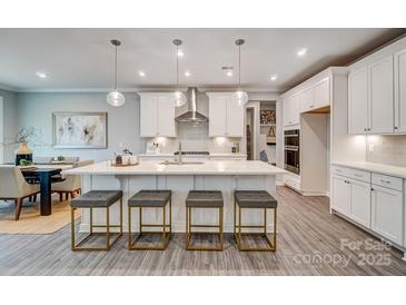 Bright, modern kitchen featuring a large island with seating, stainless steel appliances, and ample cabinet space at 9831 Quercus Ln, Huntersville, NC 28078