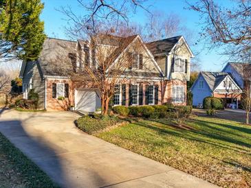 Two-story house with brick and siding, featuring a large driveway and landscaped yard at 125 Musketball Ct, Indian Trail, NC 28079