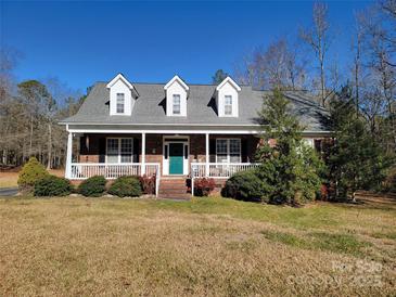 Brick ranch house with front porch, dormer windows, and landscaped yard at 2043 Hunters Ridge Rd, Lancaster, SC 29720