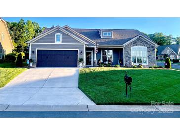 Charming single-story home boasts a dark garage, stone accents, and well-manicured lawn at 3100 Glacier Ct, Gastonia, NC 28056