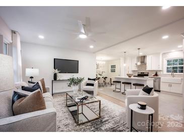 Bright living room features an open floor plan, stylish furniture, and a view into the kitchen at 7001 Starvalley Dr, Charlotte, NC 28210