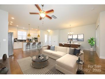 Open-concept living space featuring a modern kitchen, dining area, and a cozy seating arrangement at 7542 Waverly Walk Ave # 7542, Charlotte, NC 28277