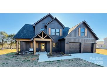 Two-story farmhouse with gray siding, two-car garage, and covered porch at 187 Lone Pine Rd, Statesville, NC 28625