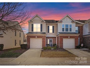 Brick front two-story townhome with attached garage and landscaping at 2430 Kensington Station Pkwy, Charlotte, NC 28210