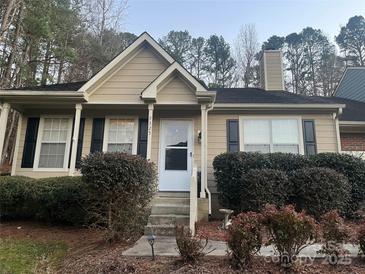 Tan house with white door, landscaping, and black shutters at 9325 Four Mile Creek Rd, Charlotte, NC 28277