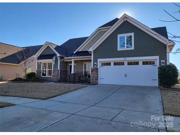 Two-story house with green siding, stone accents, and a two-car garage at 1410 Tranquility Blvd, Lancaster, SC 29720