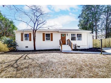 Charming white brick home featuring brown shutters, a wood door, and landscaped front yard at 5113 Grice Ct, Charlotte, NC 28210