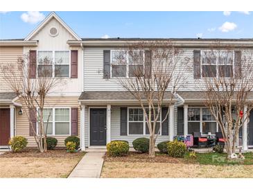 Two-story townhome with gray and beige siding, landscaping, and a patio at 611 Cahill Ln, Fort Mill, SC 29715