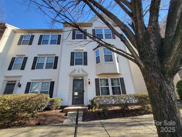 Three-story townhome with front yard landscaping and a charming facade at 9323 Lenox Pointe Dr, Charlotte, NC 28273