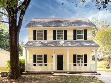 Two-story yellow house with black shutters and a front porch at 104 Pratt St, Belmont, NC 28012