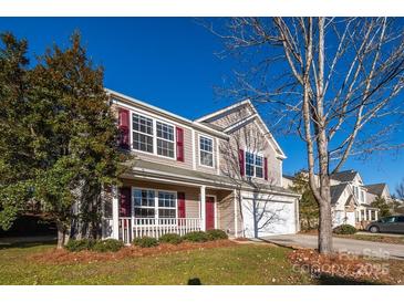 Two-story house with taupe vinyl siding, red accents, and a two-car garage at 10502 Haddington Nw Dr, Charlotte, NC 28269