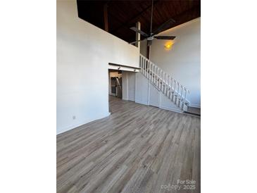 Open living room with loft and hardwood floors at 201 S Hoskins Rd # 122, Charlotte, NC 28208