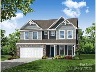 Two-story house with gray siding, stone accents, and a two-car garage at 3226 Mcharney Dr # 35, Harrisburg, NC 28075