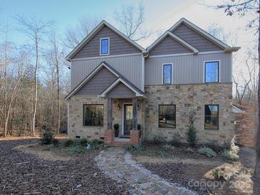 Charming home with stone and neutral siding, complemented by a stone walkway and inviting front porch at 600 E Monbo Rd, Statesville, NC 28677