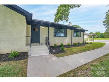 Updated ranch home exterior with fresh paint, landscaping, and carport at 6211 Rock Island Rd, Charlotte, NC 28278