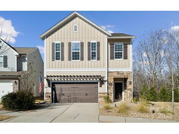 Two-story house with beige siding, brown garage door, and stone accents at 1248 Thomas Knapp Pkwy, Fort Mill, SC 29715