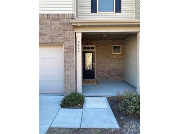 Brick front exterior with covered porch and two-car garage at 9446 Avery Lilac Ln, Fort Mill, SC 29707