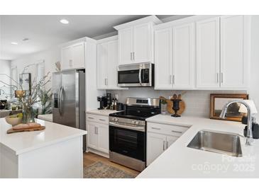 Modern kitchen with white cabinets, stainless steel appliances, and quartz countertops at 1140 Evergreen View Ln # 17, Charlotte, NC 28212