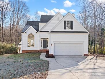 White two-story house with a gray door and two-car garage at 124 Lyman Oak Ct, Fort Mill, SC 29715